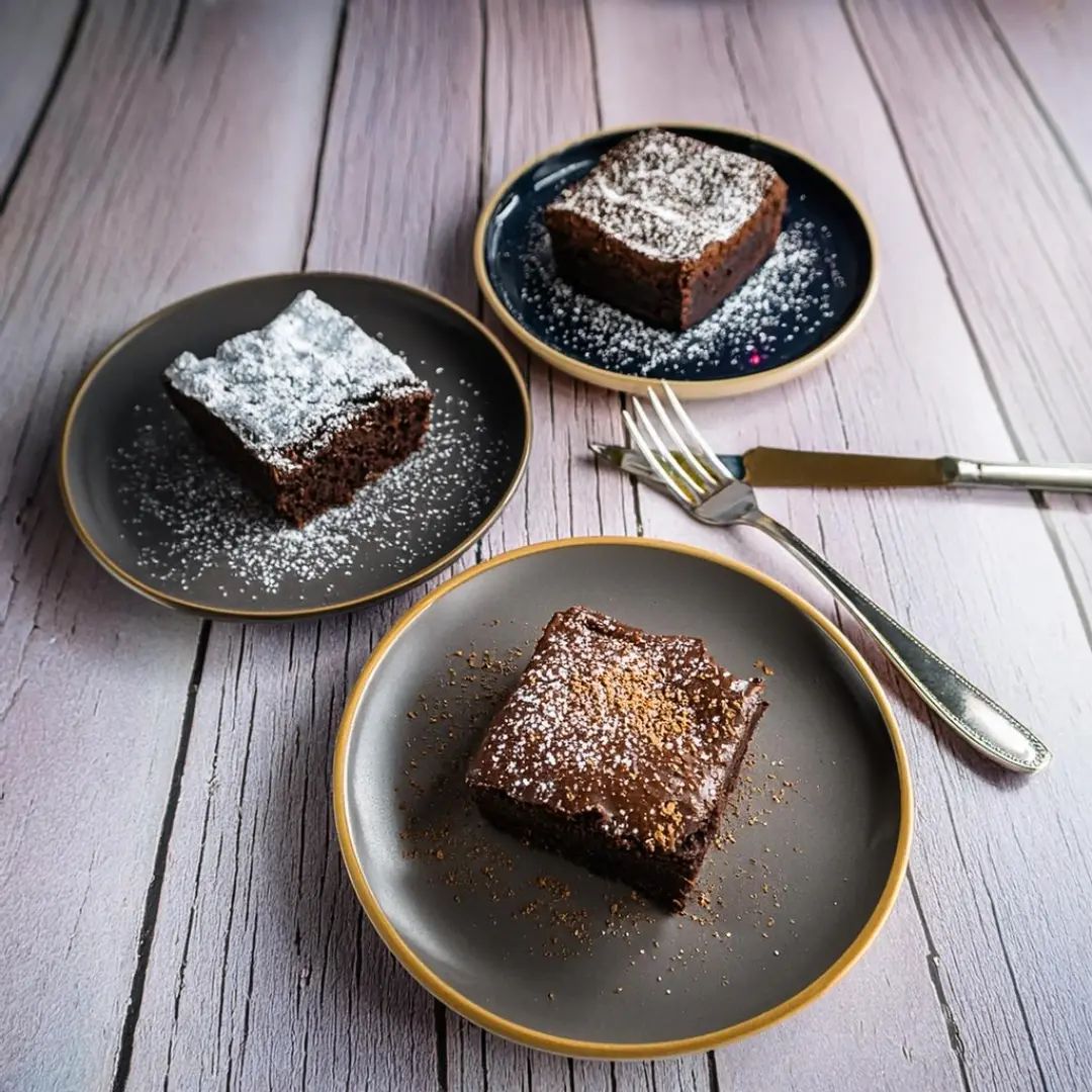 Fudgy, cakey, and chewy brownies served on separate plates.