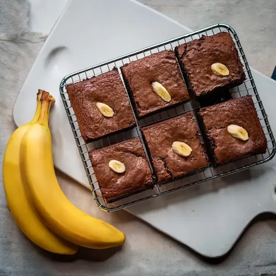 Banana brownies cooling on a wire rack, golden and gooey.