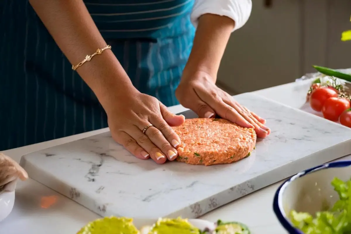 Shaping the salmon patty mixture on a white marble board