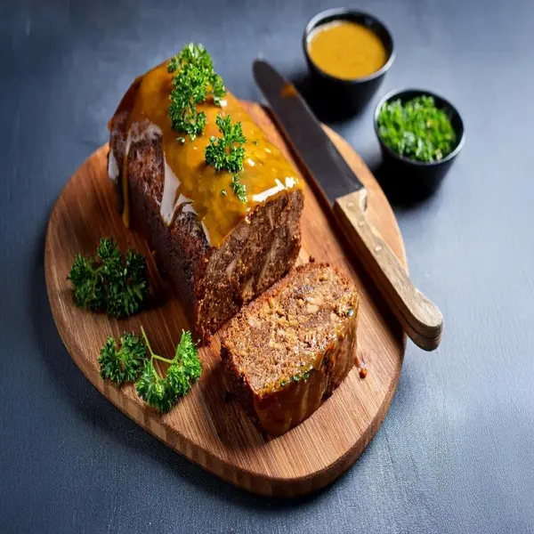 Honey mustard glaze on meatloaf with parsley garnish.