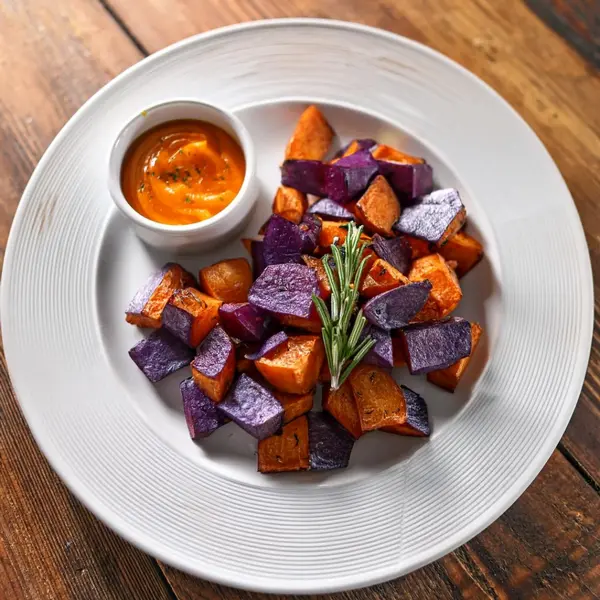 Roasted purple sweet potato dish garnished with herbs