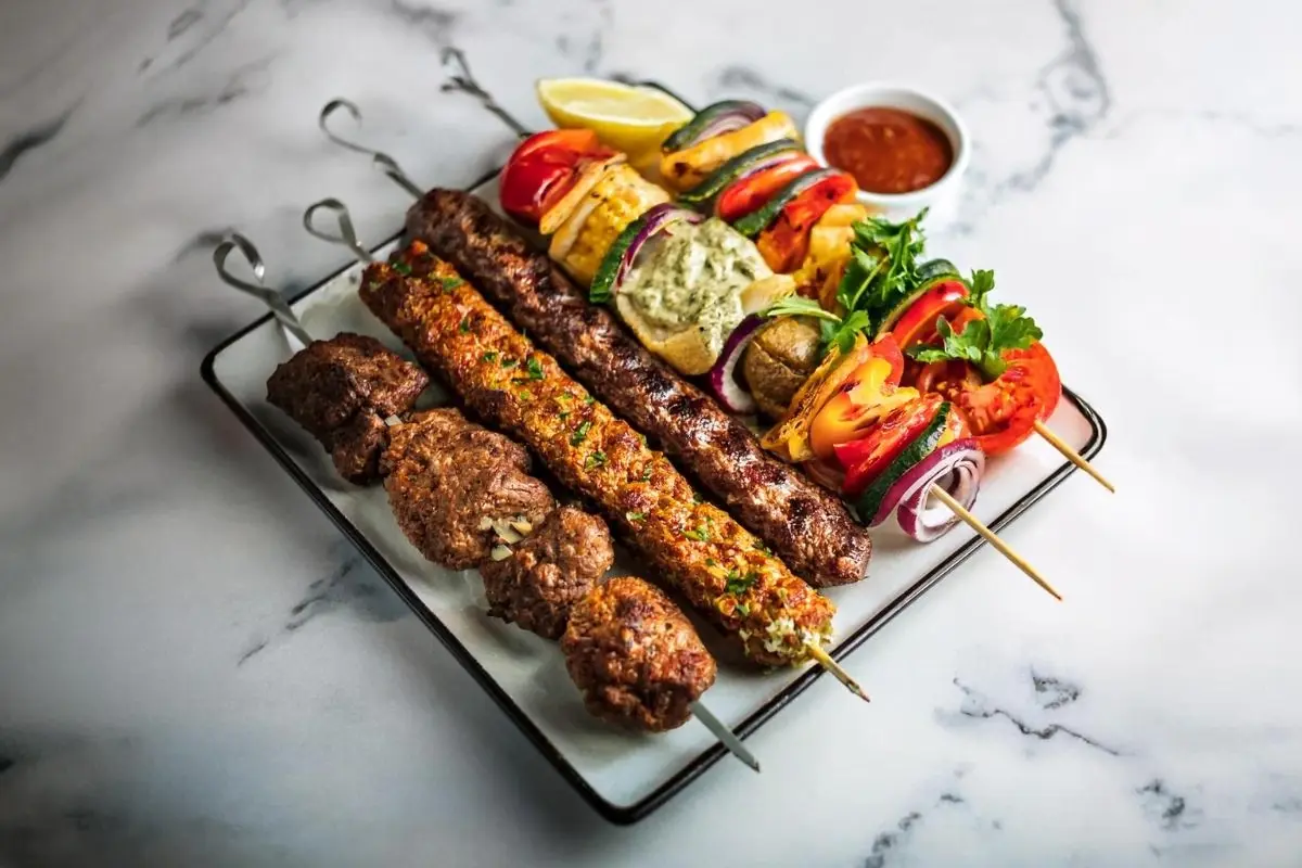 A variety of kebabs including Adana, shish, and doner, arranged on a serving platter.