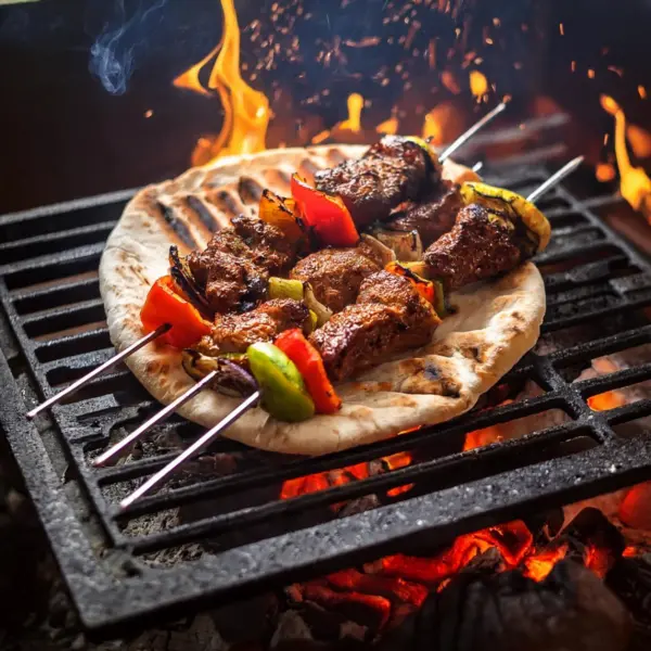 Turkish kebabs grilling over charcoal, with spices like paprika and cumin visible on the meat’s surface.