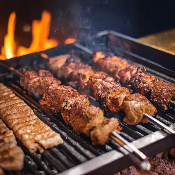 Adana Kebab (spiced minced lamb) and Shish Kebab (cubed meat) grilling over charcoal.